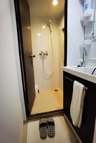 a bathroom with a shower and two pairs of shoes at belle via tokyo - Vacation STAY 58509v in Tokyo