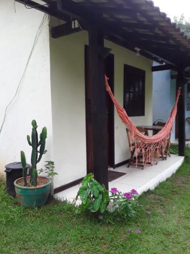 a porch of a house with a chair and a cactus at Cantinho da Serra do Sana in Macaé