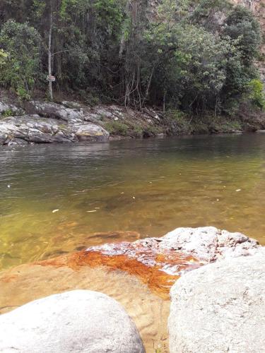Un río con algunas rocas en el agua en Cantinho da Serra do Sana, en Macaé
