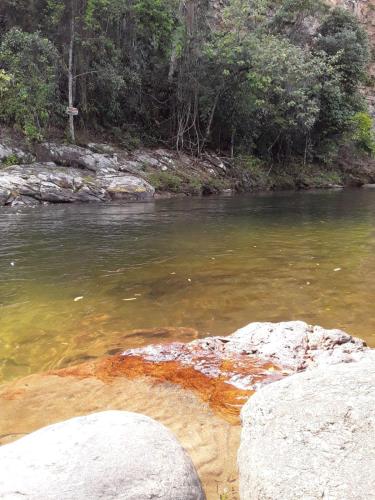 a river with some rocks in the water at Cantinho da Serra do Sana in Macaé