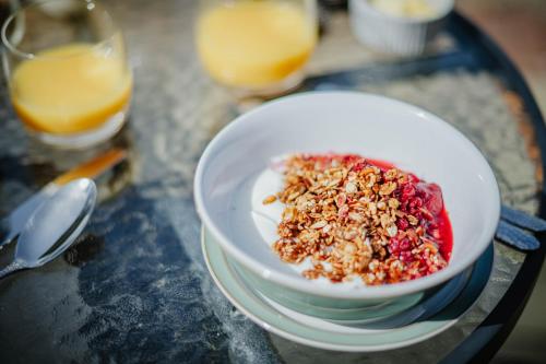 a bowl of food on a table with glasses of orange juice at Hanley House in Tenbury