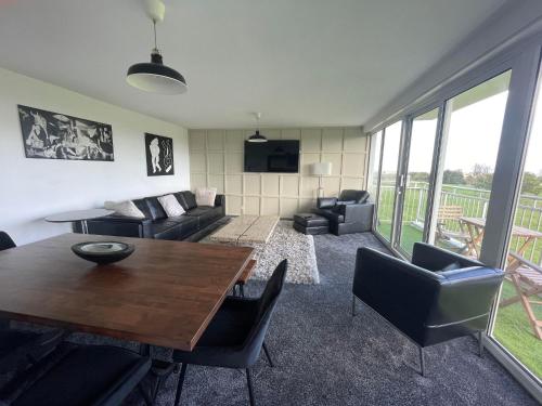 a living room with a table and chairs at 3 Bedroom Apartment with Golf Course View in Newcastle upon Tyne