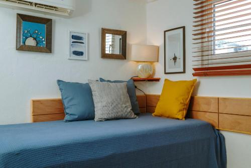1 dormitorio con 1 cama con almohadas azules y amarillas en "Le Petit Bonheur" Cozy studio near beach, en Puerto Vallarta