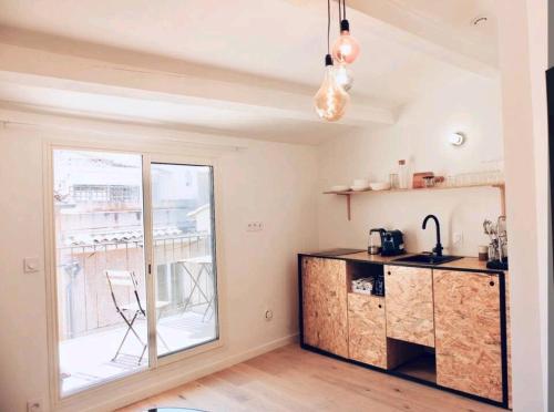 d'une cuisine avec un comptoir, un évier et une fenêtre. dans l'établissement Studio centre historique Aix, à Aix-en-Provence