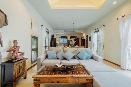 a living room with a couch and a coffee table at Ivory Pool Villa in Nai Harn in Rawai Beach