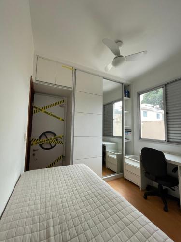a bedroom with a bed and a desk and a chair at Apê na Pampulha 3Q, Ar Split, Churrasco e 2 Vagas in Belo Horizonte