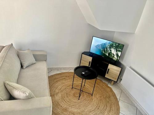 ein Wohnzimmer mit einem Sofa und einem runden Tisch in der Unterkunft Quartier de l'Hôtel des Bains in Moirans