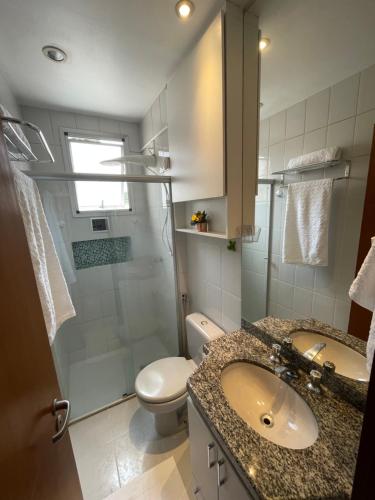 a bathroom with a sink and a toilet and a shower at Apê na Pampulha 3Q, Ar Split, Churrasco e 2 Vagas in Belo Horizonte