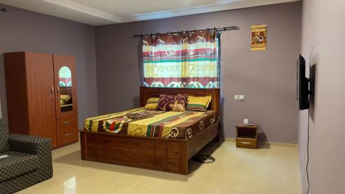 AshalebotweにあるGilbert Dai Venturesのベッドルーム1室(壁にカーテン付きのベッド1台付)
