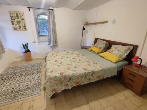 a bedroom with a bed and a dresser and a window at גינה ירושלמית in Jerusalem