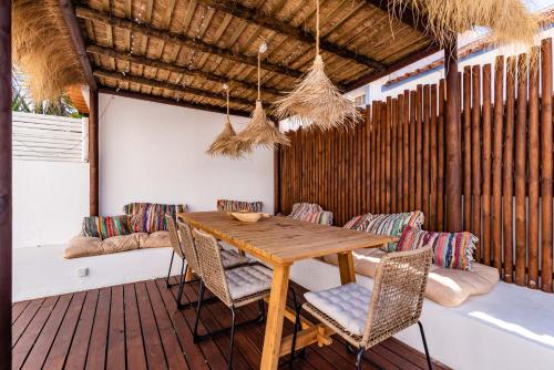 a wooden table and chairs on a deck at Mermaid Cottage in Comporta