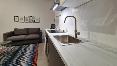 una cucina con lavandino e divano di Le Suites Moderne a Milano