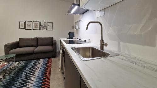 a kitchen with a sink and a couch at Le Suites Moderne in Milan