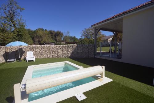 uma piscina num quintal ao lado de uma casa em Gîte D&D avec piscine privative em Martel
