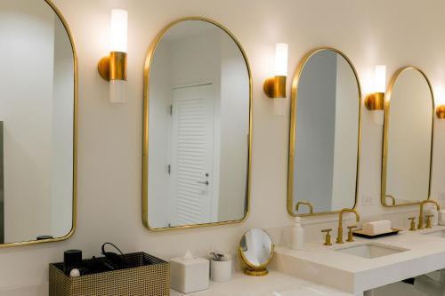 a bathroom with three mirrors and a white sink at Sheraton Carlsbad Resort & Spa in Carlsbad