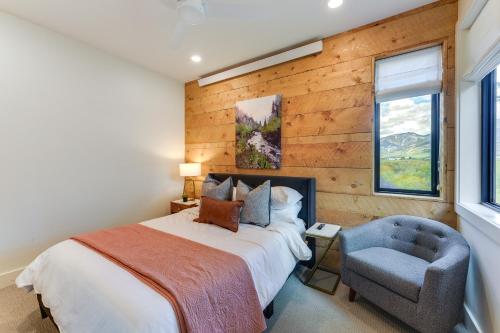 um quarto com uma cama e uma cadeira azul em Modern Turnerville Cabin with Hot Tub and Scenic Views em Thayne