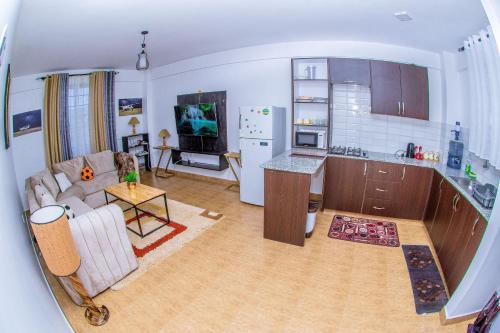 een keuken en een woonkamer met een bank en een tafel bij Penthouse in Eldoret