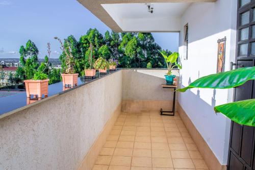 a balcony with chairs and plants on a building at Penthouse in Eldoret