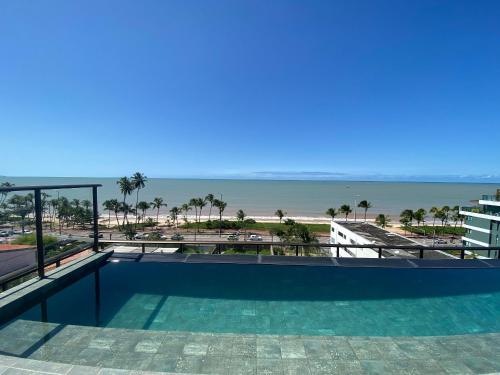 a view of the beach from the balcony of a resort at Flat FM20 Cabo Branco Stilo - By Almare in João Pessoa