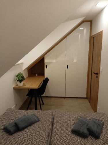 a bedroom with two beds and a desk and a table at Chalupa u Mikeše in Žďár nad Sázavou