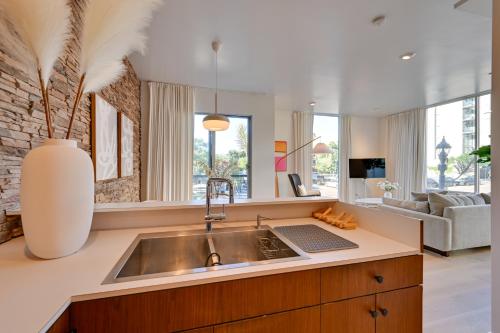 a kitchen with a sink and a living room at Rooftop with Views Modern Little Italy Townhome in San Diego