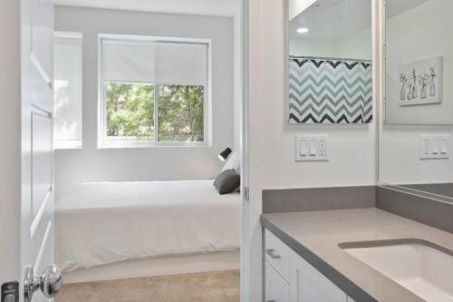 a white bathroom with a bed and a window at Bright, Modern, Central - Theater Room, Sleeps 9 in Los Angeles