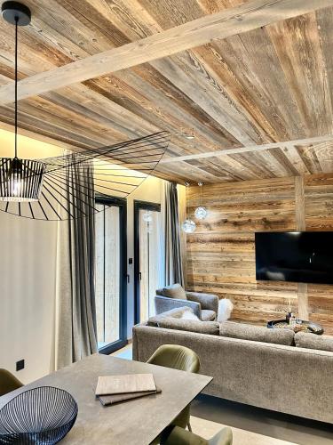 a living room with a couch and a table at Hameau des Prodains - Résidence in Morzine