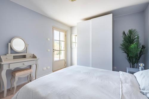 a bedroom with a white bed and a mirror at La Magnanella - Luxury B&B in Fornovo di Taro