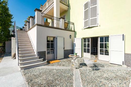 a white house with a staircase and a patio at La Magnanella - Luxury B&B in Fornovo di Taro