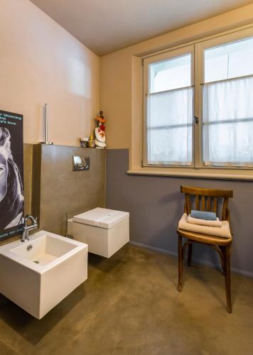 a bathroom with a sink and a chair and a window at La Magnanella - Luxury B&B in Fornovo di Taro
