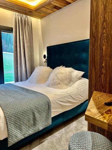 a bedroom with a large bed with a blue headboard at Hameau des Prodains - Résidence in Morzine