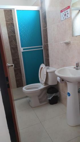 a bathroom with a toilet and a sink at Hotel Las Marias in Puerto López