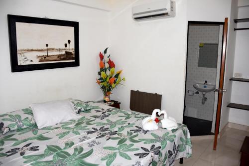 a bedroom with a bed with a flower on it at Hotel Las Marias in Puerto López