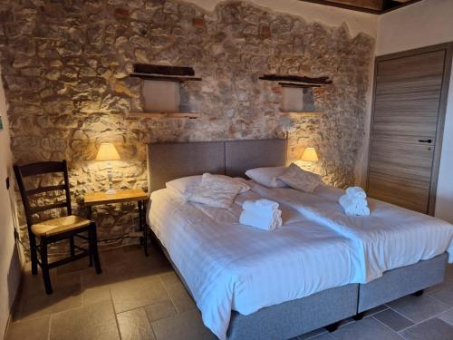 a bedroom with a bed and a stone wall at Agriturismo La Pina in Tarzo