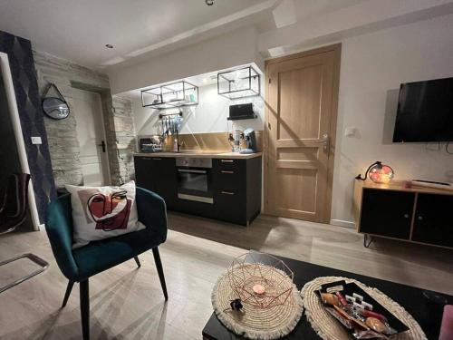 Una sala de estar con una silla y una cocina. en - NEW - Le CherBlue - WiFi / Netflix, en Cherbourg-en-Cotentin