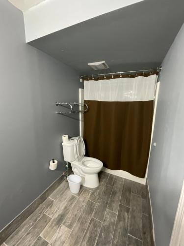 a bathroom with a toilet and a shower curtain at SUNSET INN in Branson