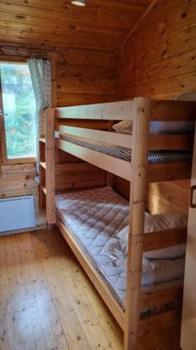 a bedroom with two bunk beds in a log cabin at Lomariihi 11 in Muurame