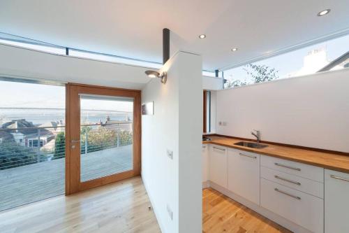 Una cocina con gabinetes blancos y una ventana grande. en The Nook, Studio Apartment, South Queensferry, en Queensferry