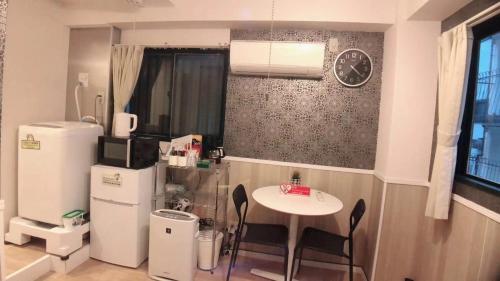 Il comprend une cuisine équipée d'une table, d'un réfrigérateur et d'une horloge. dans l'établissement Jing House Koiwa - Vacation STAY 62678v, à Tokyo
