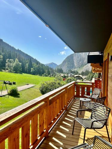 a deck with chairs and a view of a mountain at Hameau des Prodains - Résidence in Morzine