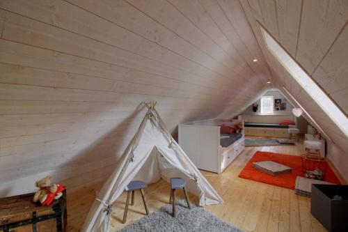 une chambre avec une tente au milieu d'un grenier dans l'établissement Superbe gîte 8/16 personnes, Saint Lary, à Vielle-Aure