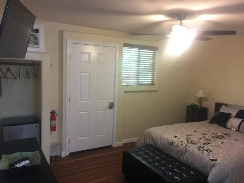 a bedroom with a bed and a ceiling fan at Aaron’s cottage in Hilo