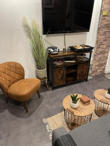 a living room with a tv and chairs and tables at Casa di maksch de miniatura in Amsterdam