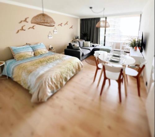 ein Schlafzimmer mit einem Bett und einem Tisch sowie ein Esszimmer in der Unterkunft Studio Sea View - Royal Ascot in Ostende