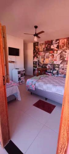 a bedroom with a bed and a ceiling fan at Pousada Blues in Ipiabas
