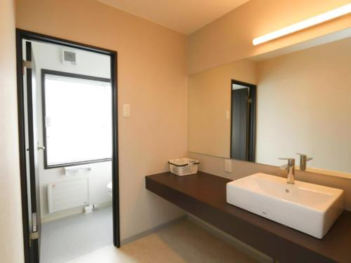 W łazience znajduje się biała umywalka i lustro. w obiekcie KAMUY RERA - Vacation STAY 62288v w mieście Kushiro