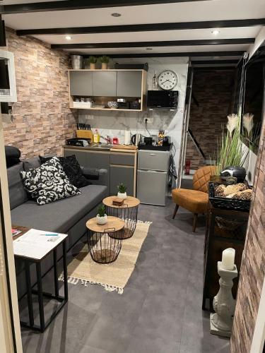 a living room with a couch and tables and a kitchen at Casa di maksch de miniatura in Amsterdam