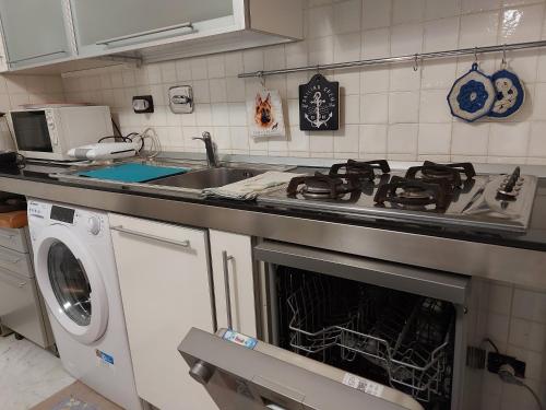 a kitchen with a stove and a washing machine at APPARTAMENTO SUL MARE KATE in Genoa