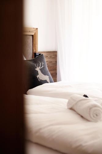 a bedroom with two beds with a deer pillow at Alpenstolz Damüls Haus 3 - Stilvoll urlauben in den Bergen in Damuls