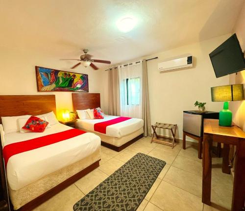 a hotel room with two beds and a desk at El Roble Hotel in Bacalar